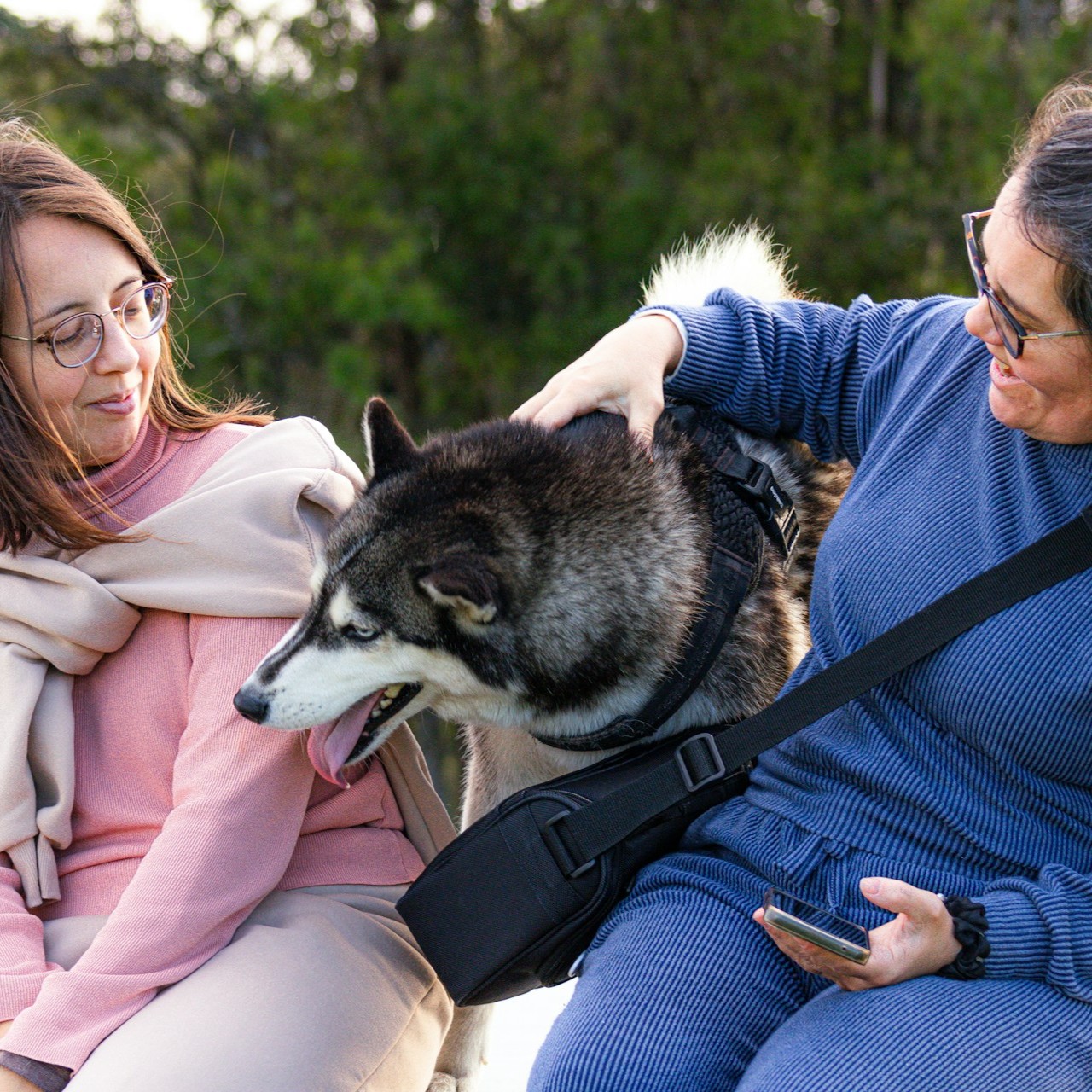 two-girls-are-sitting-with-her-dog